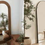 Black arch mirror positioned above a console table in a bright UK hallway