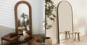 Black arch mirror positioned above a console table in a bright UK hallway