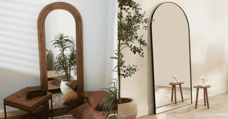 Black arch mirror positioned above a console table in a bright UK hallway