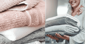 Stack of fluffy white bath towels neatly folded on a wooden bathroom shelf