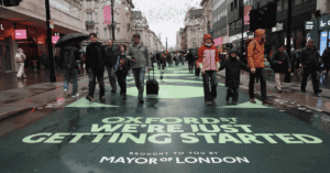 Crowds walking along a traffic-free Oxford Street in central London with historic department stores in view